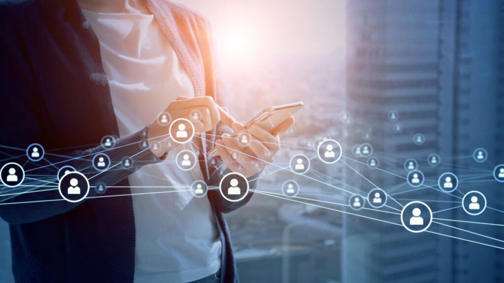 スマートフォンを操作する人物の周囲に、顧客ネットワークを示すアイコンが広がっているイメージ画像。