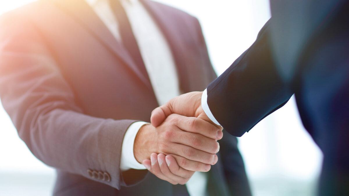 スーツ姿のビジネスパーソンが握手を交わす様子。信頼関係とパートナーシップを象徴するイメージ。